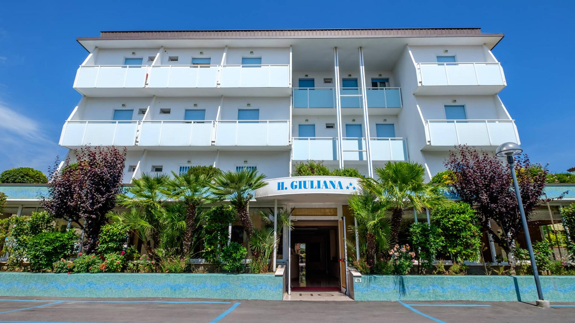 Modern hotel with balconies, garden, and parking.