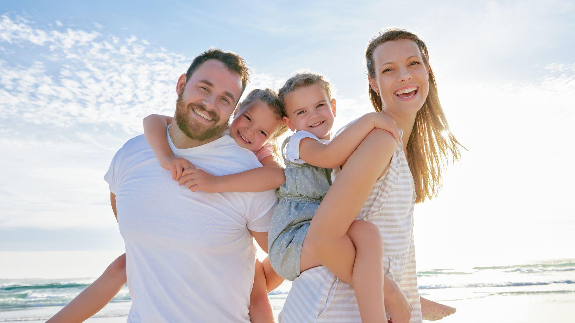 Famiglia felice in spiaggia con il sole splendente.