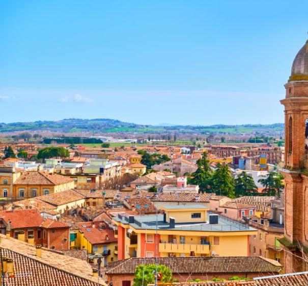 Vista su una città italiana con campanile e tetti rossi.