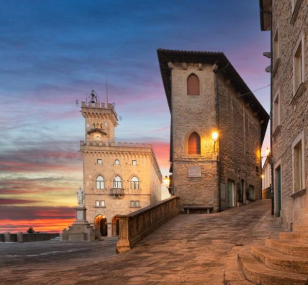 Strada acciottolata al tramonto con edifici storici.