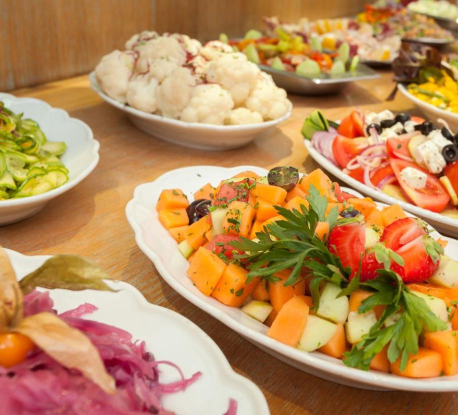 Varietà di insalate fresche e colorate su piatti da portata.