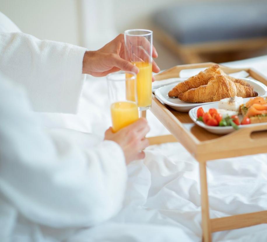 Colazione a letto con croissant e succo d'arancia.