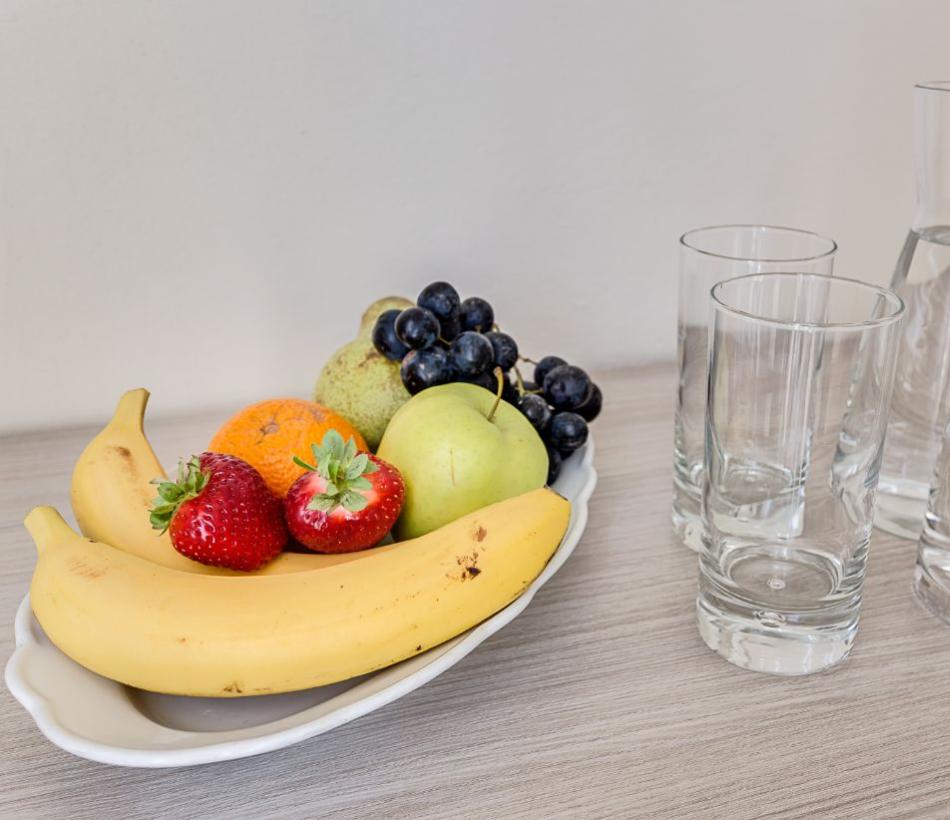 Frutta fresca e caraffe d'acqua su un tavolo.