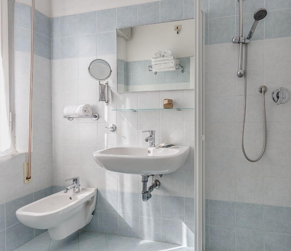 Bagno moderno con doccia, bidet e lavabo.